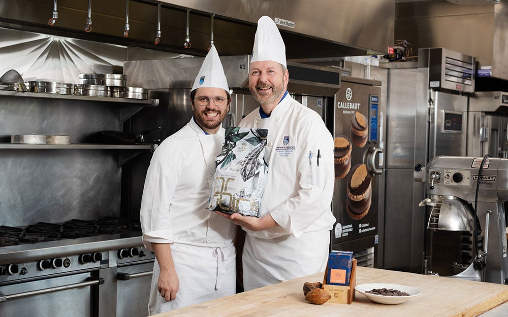 Two men in chef uniforms in a kitchen
