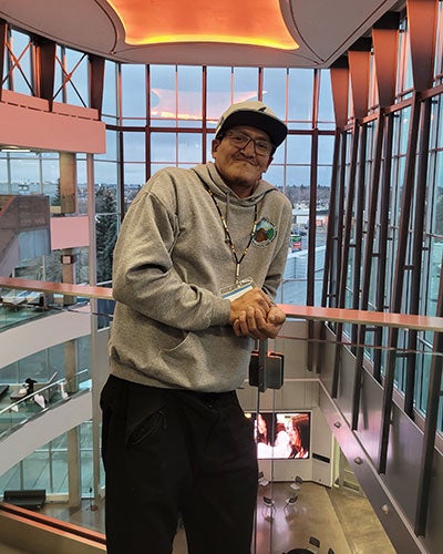 A man standing in a room with a glass wall and a window