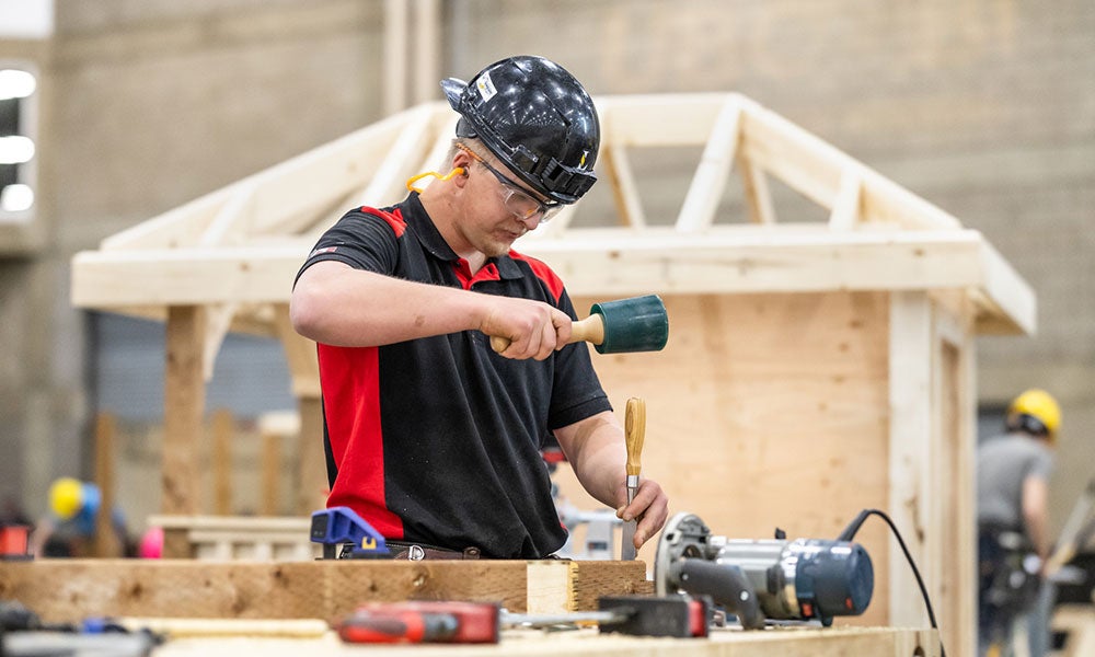 A man wearing a helmet and holding a hammer