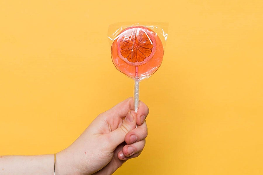 A hand holding a lollipop