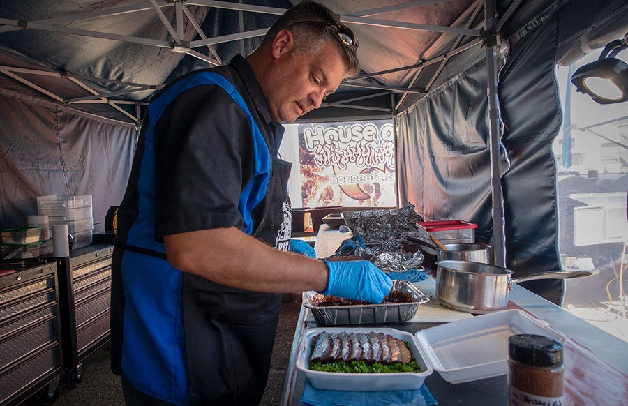 A man in a blue and black uniform preparing food