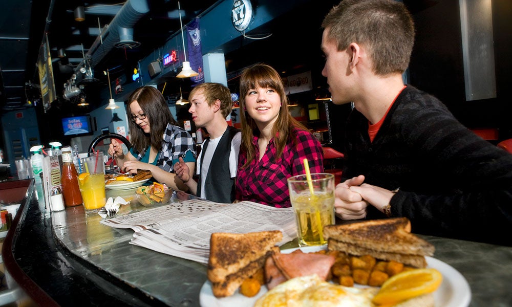 A group of people sitting at a table with food