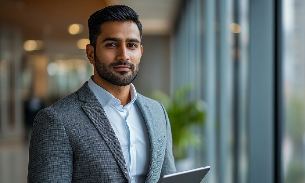 A man in a suit holding a tablet