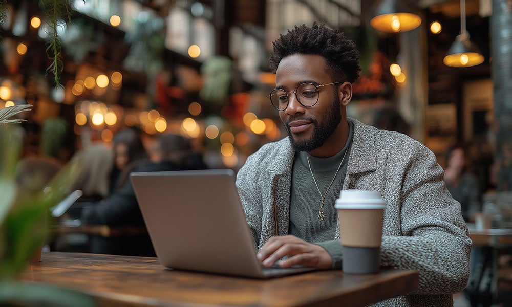 A man sitting at a table with a laptop