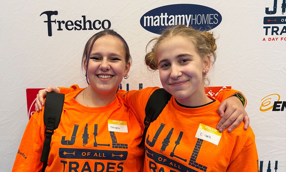 Two girls wearing matching orange shirts