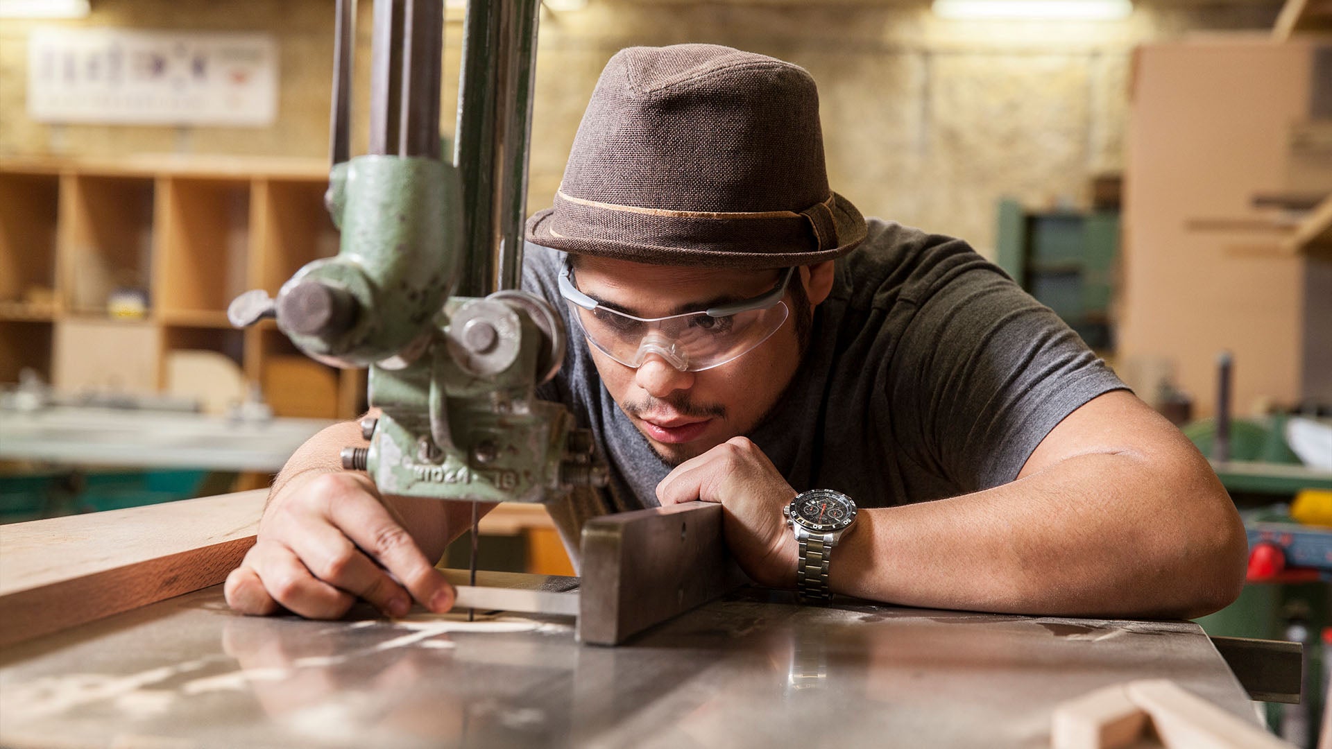 Cabinetmaker looking closely at bandsaw.