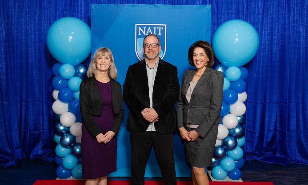 A group of people standing in front of a blue and white balloon backdrop