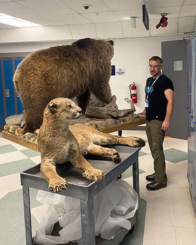 A man standing next to a stuffed bear