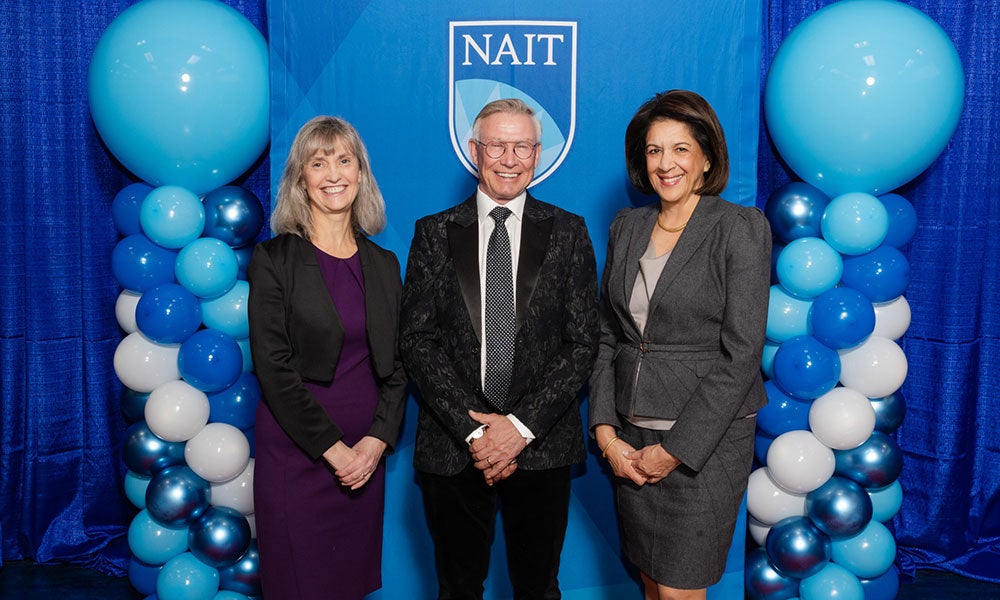 A group of people standing in front of a blue and white balloon backdrop