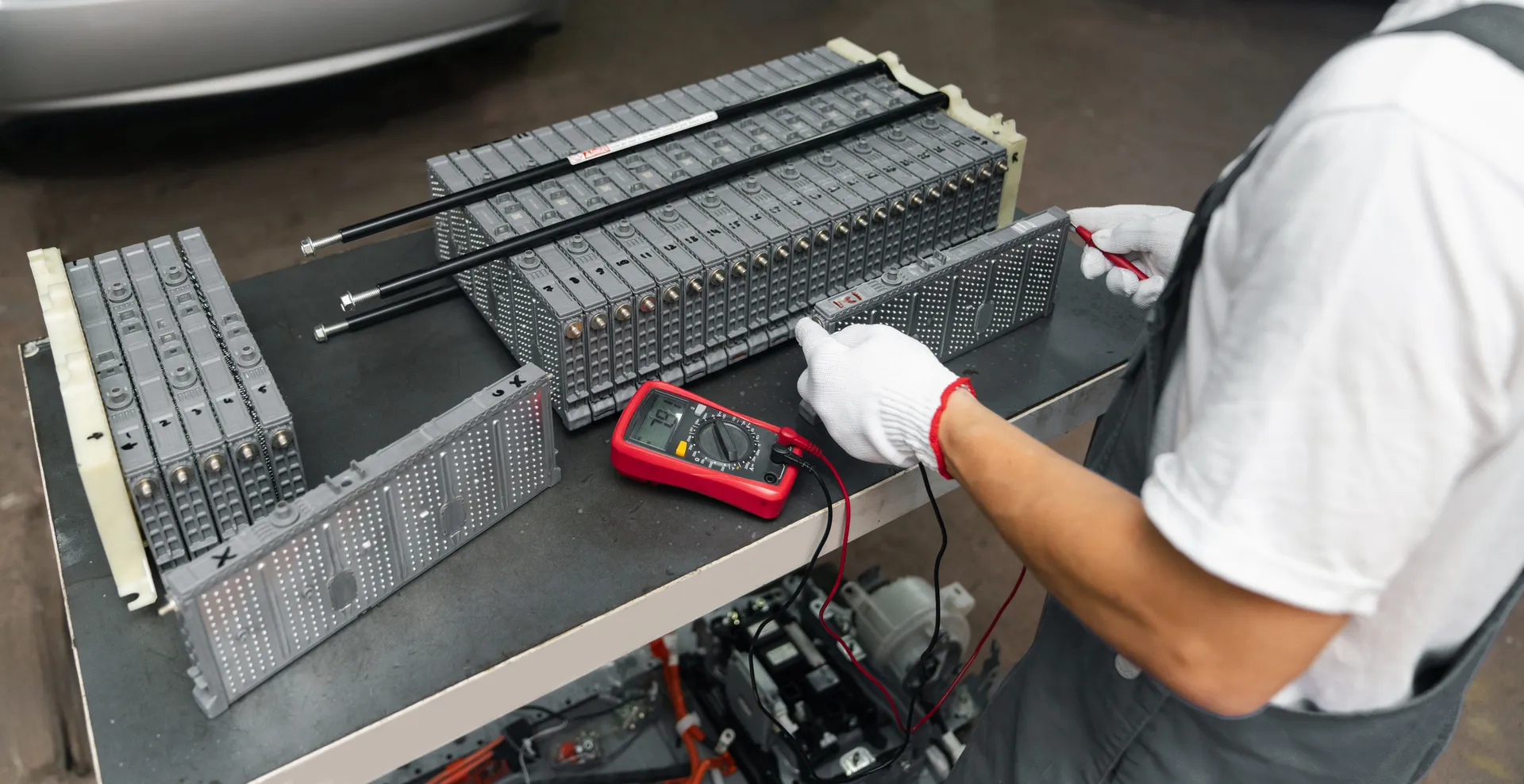 Serviceman repairs electric battery pack of hybrid car