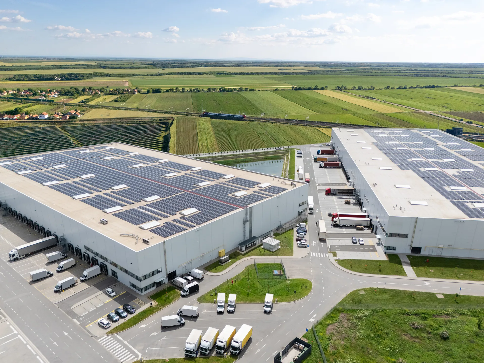 Logistics center with solar panels on roofs. Aerial view. Drone view of a modern warehouse.
