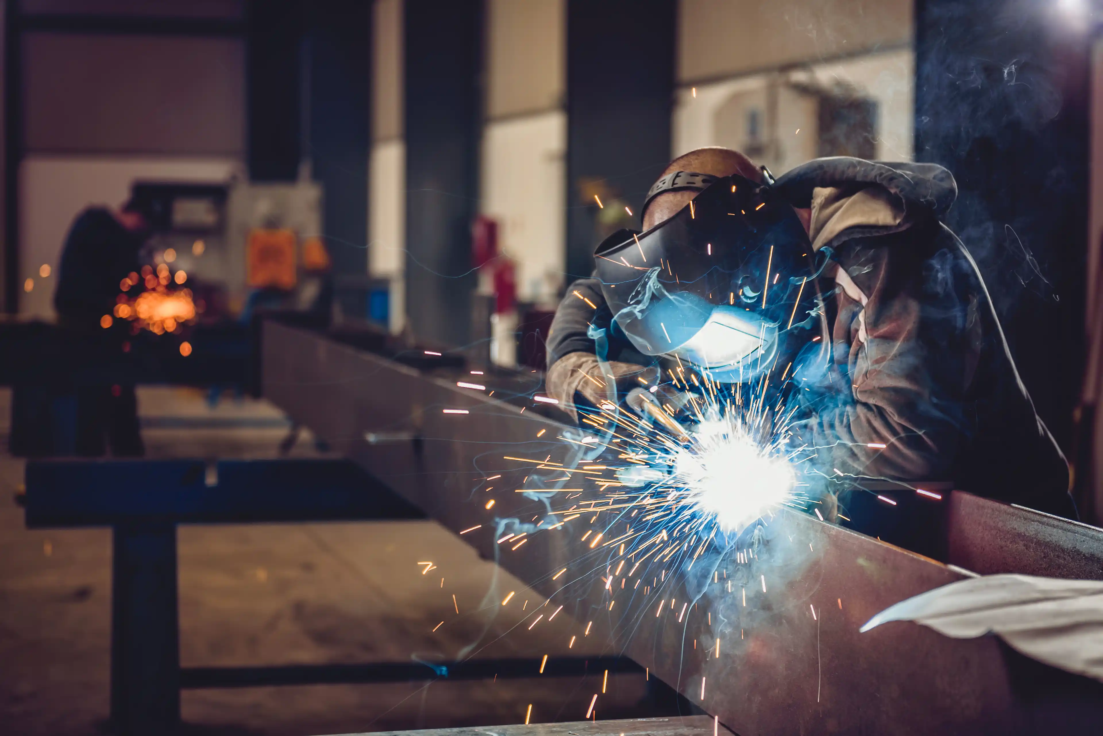Industrial welder with torch and sparks
