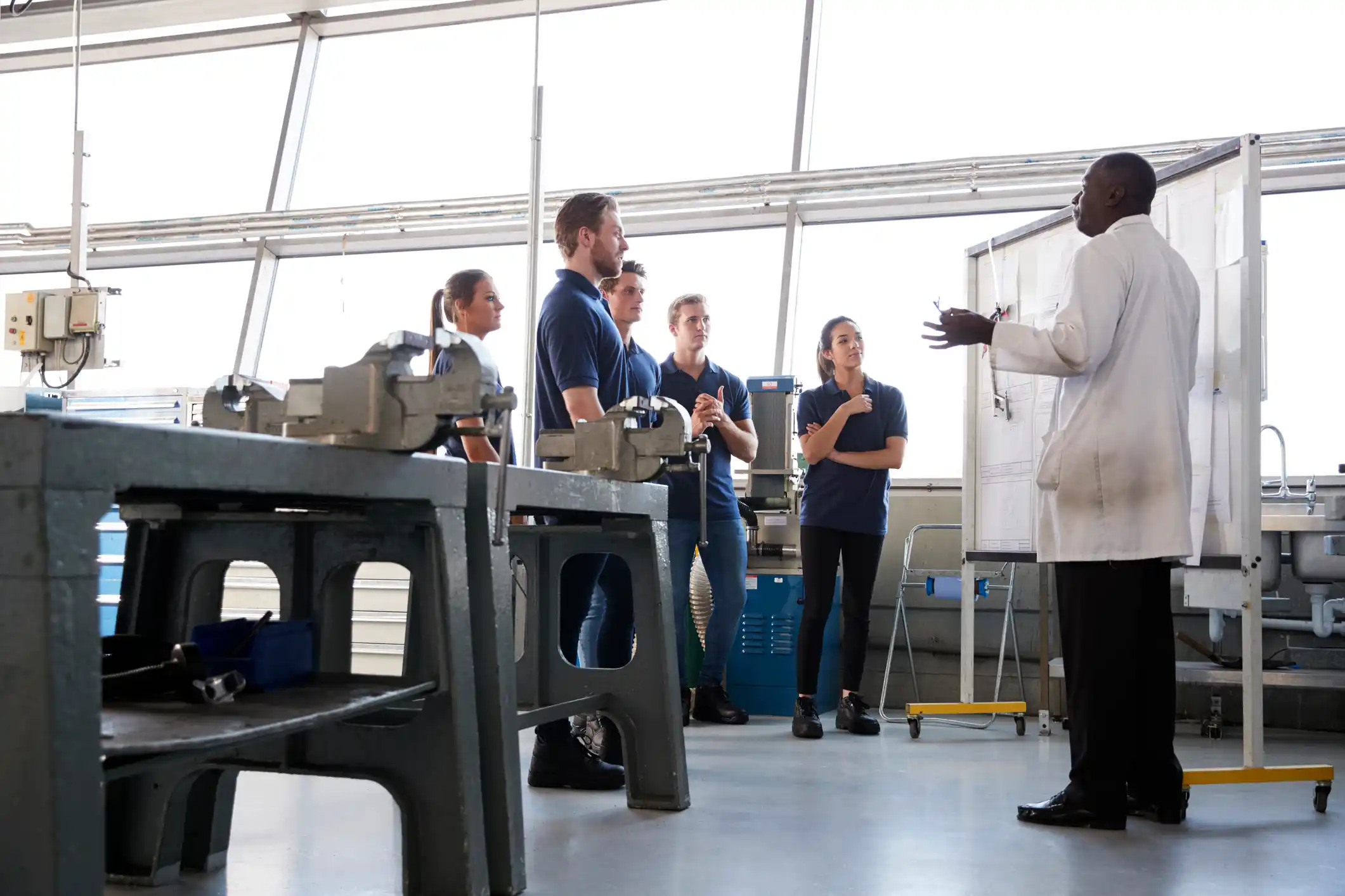 Engineering apprentices stand at a training presentation