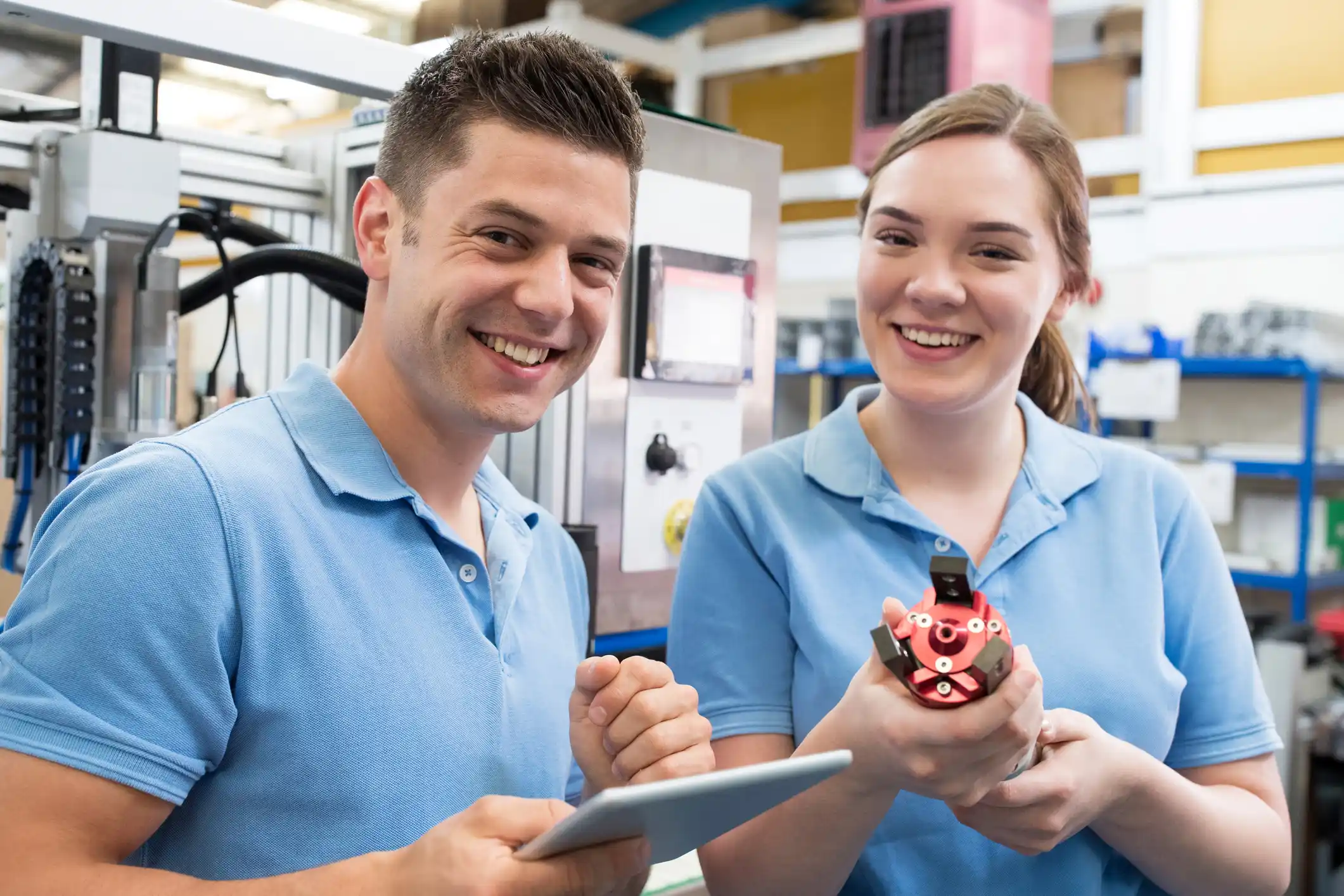 Female apprentice in an engineering lab with employer smiling