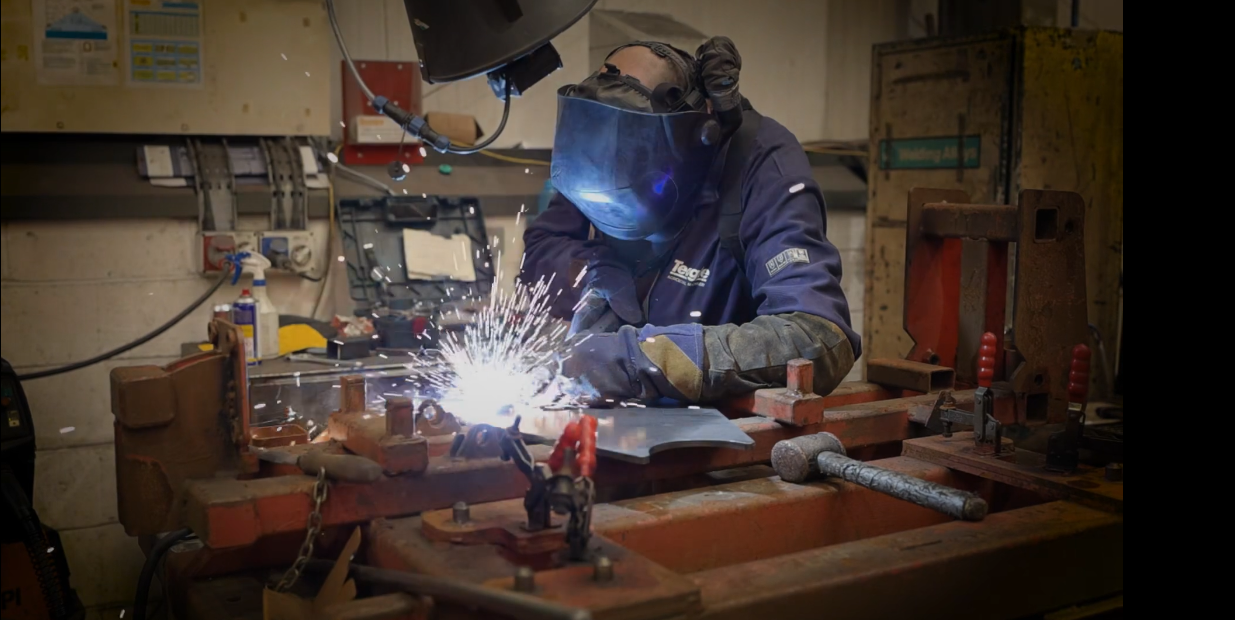 Welder works with welding equipment