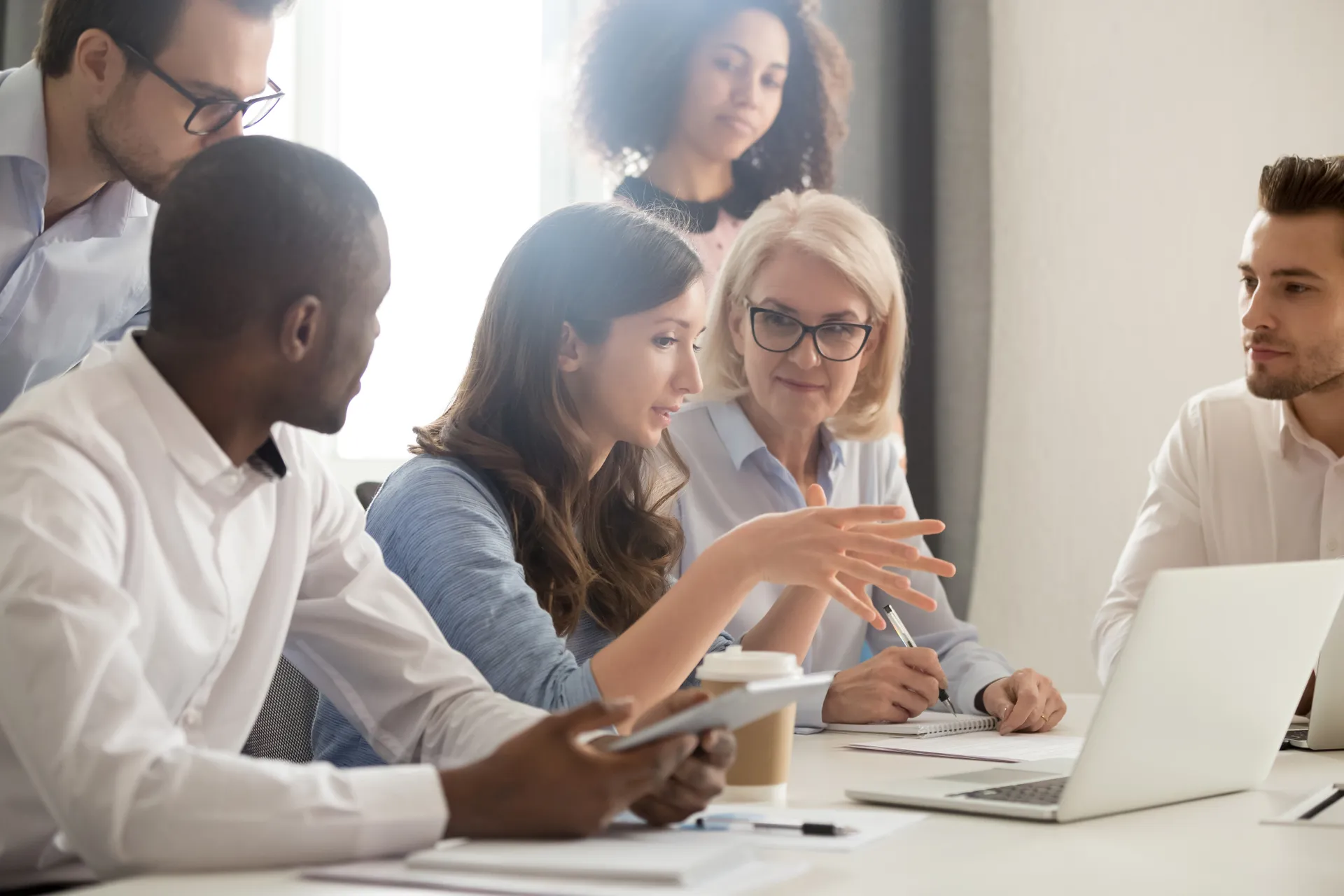 Female mentor teaching employees group analyzing online project explaining strategy 