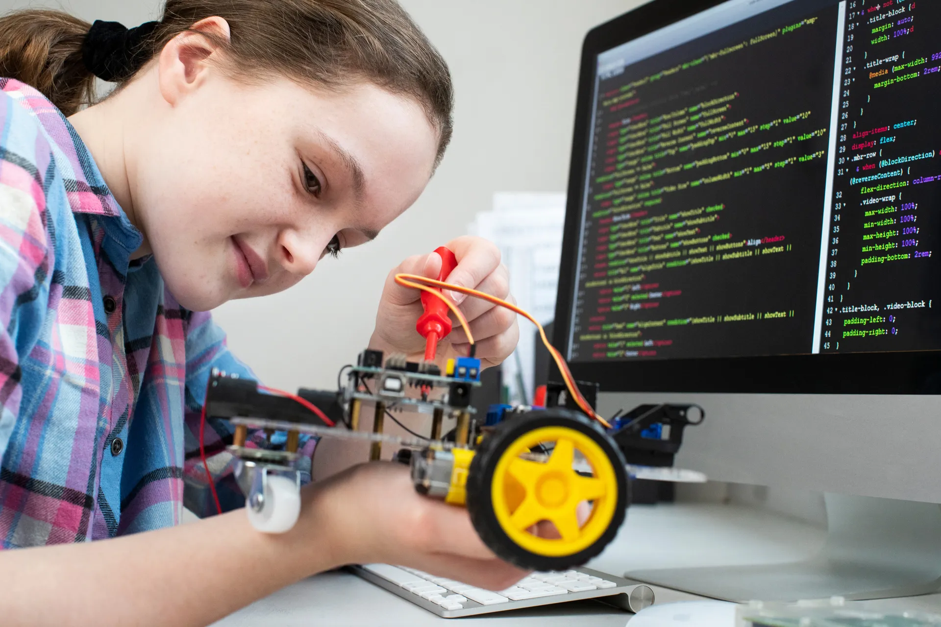 A girl learns coding by programming a robot vehicle