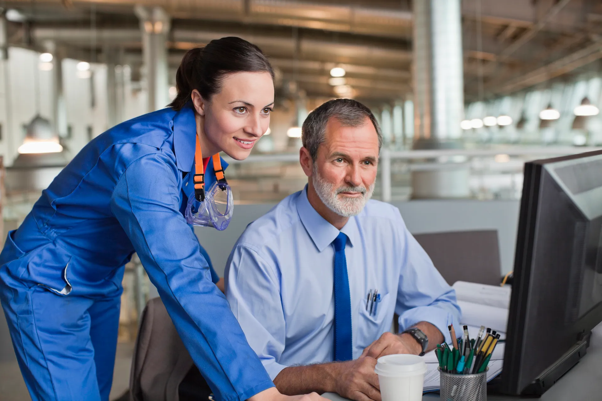 Businessman and engineer using computer in factory