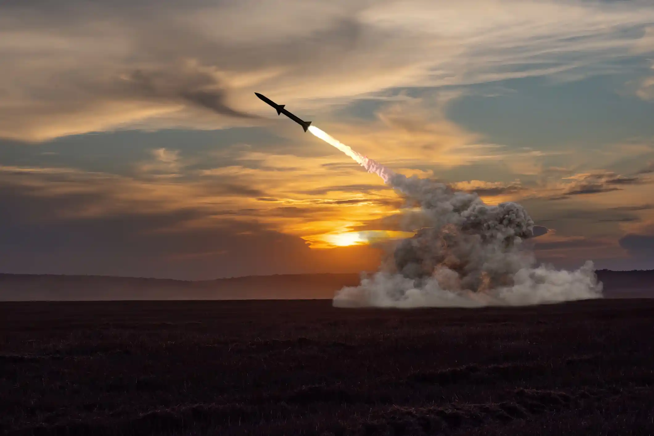 Rocket launch against the background of the evening field, the setting sun