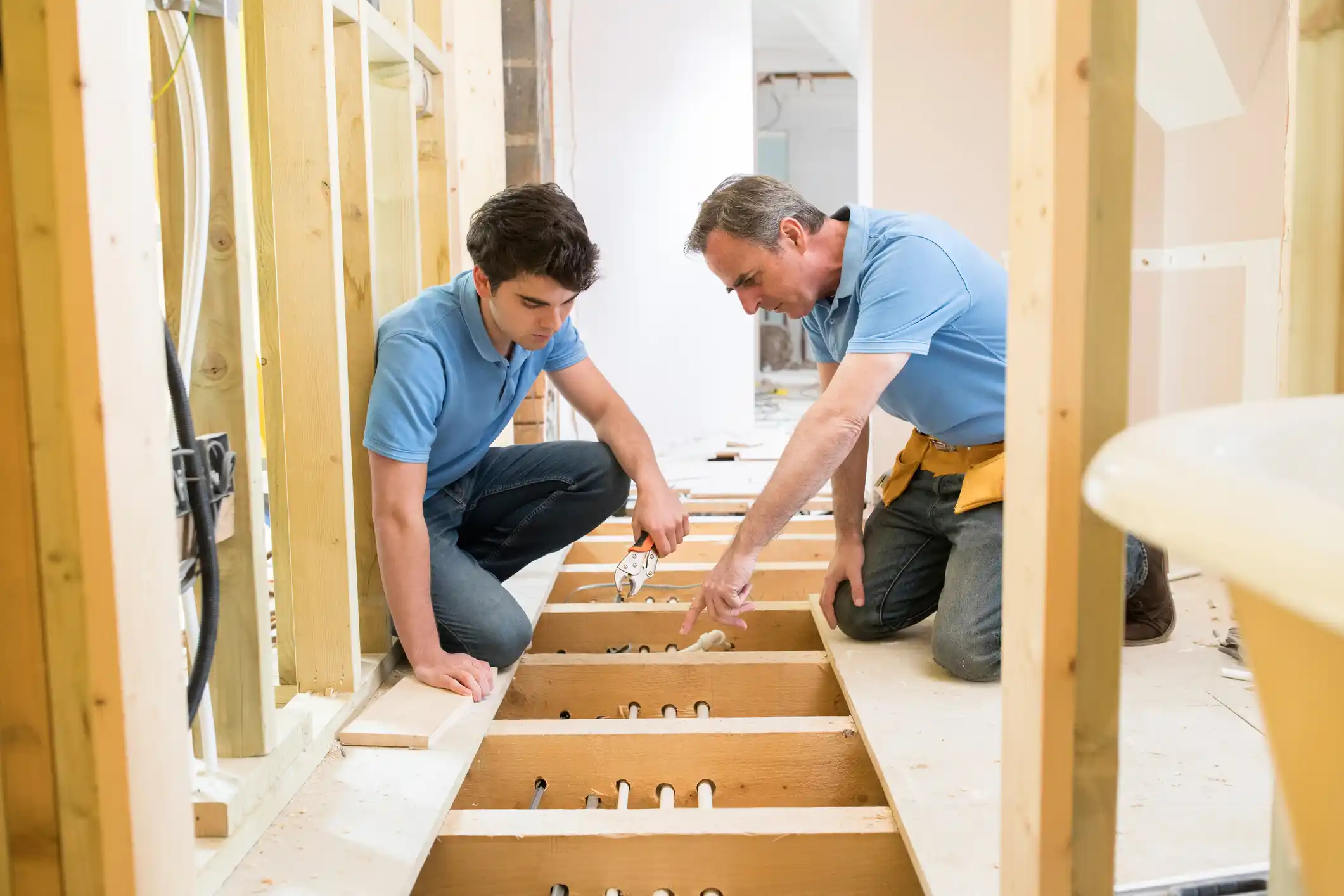 Plumber instructing apprentice
