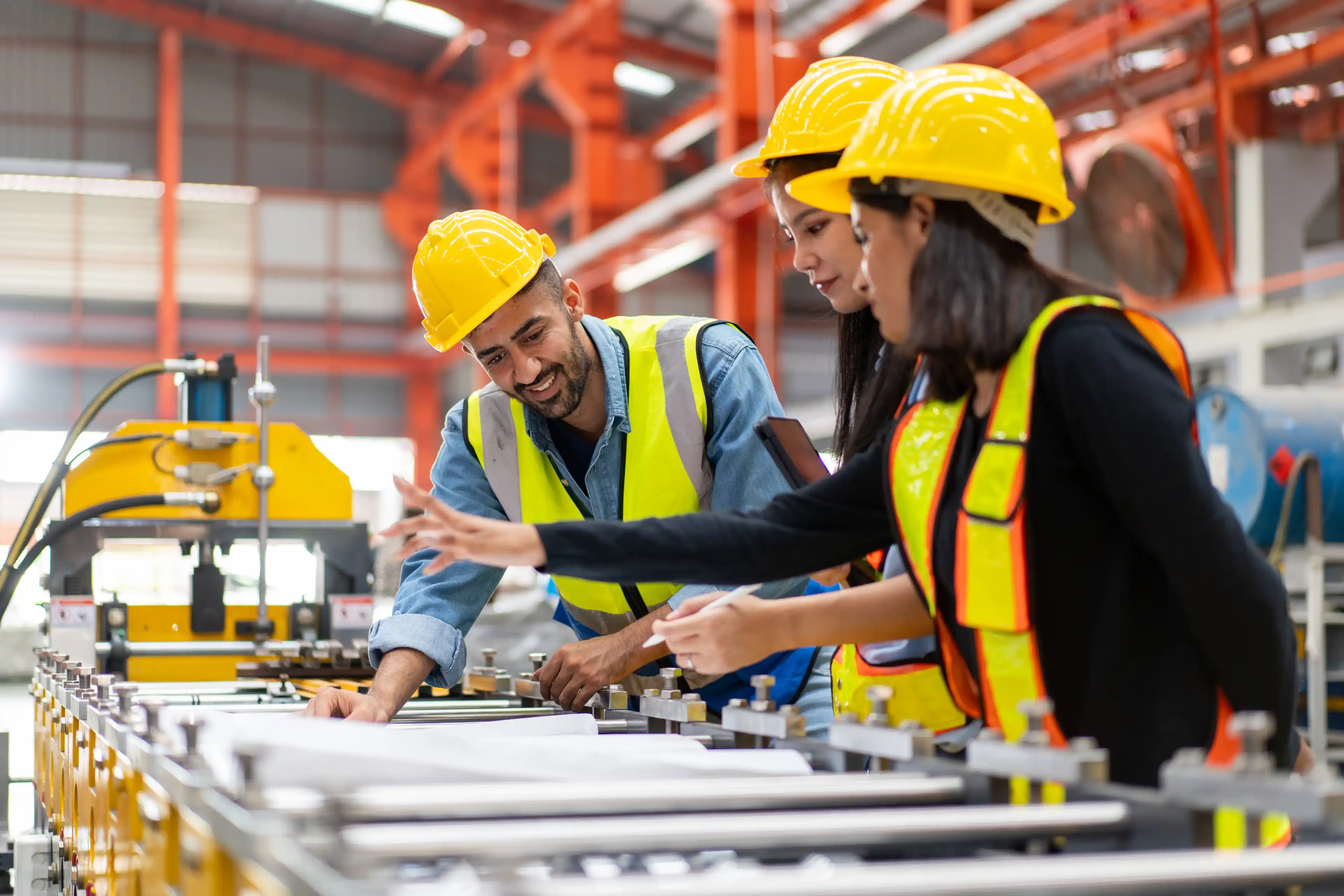 Three engineers working in hard hats and high vis vests 