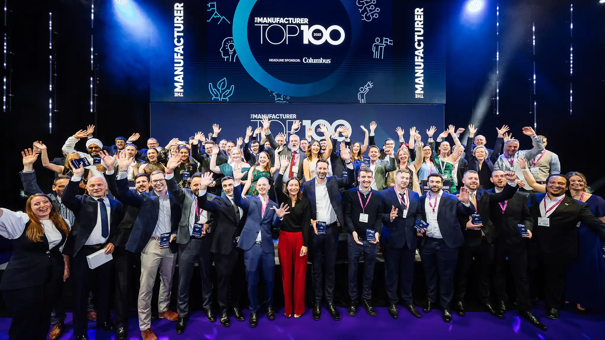 Group photo of award recipients at The Manufacturer Top 100 2025, smiling and waving