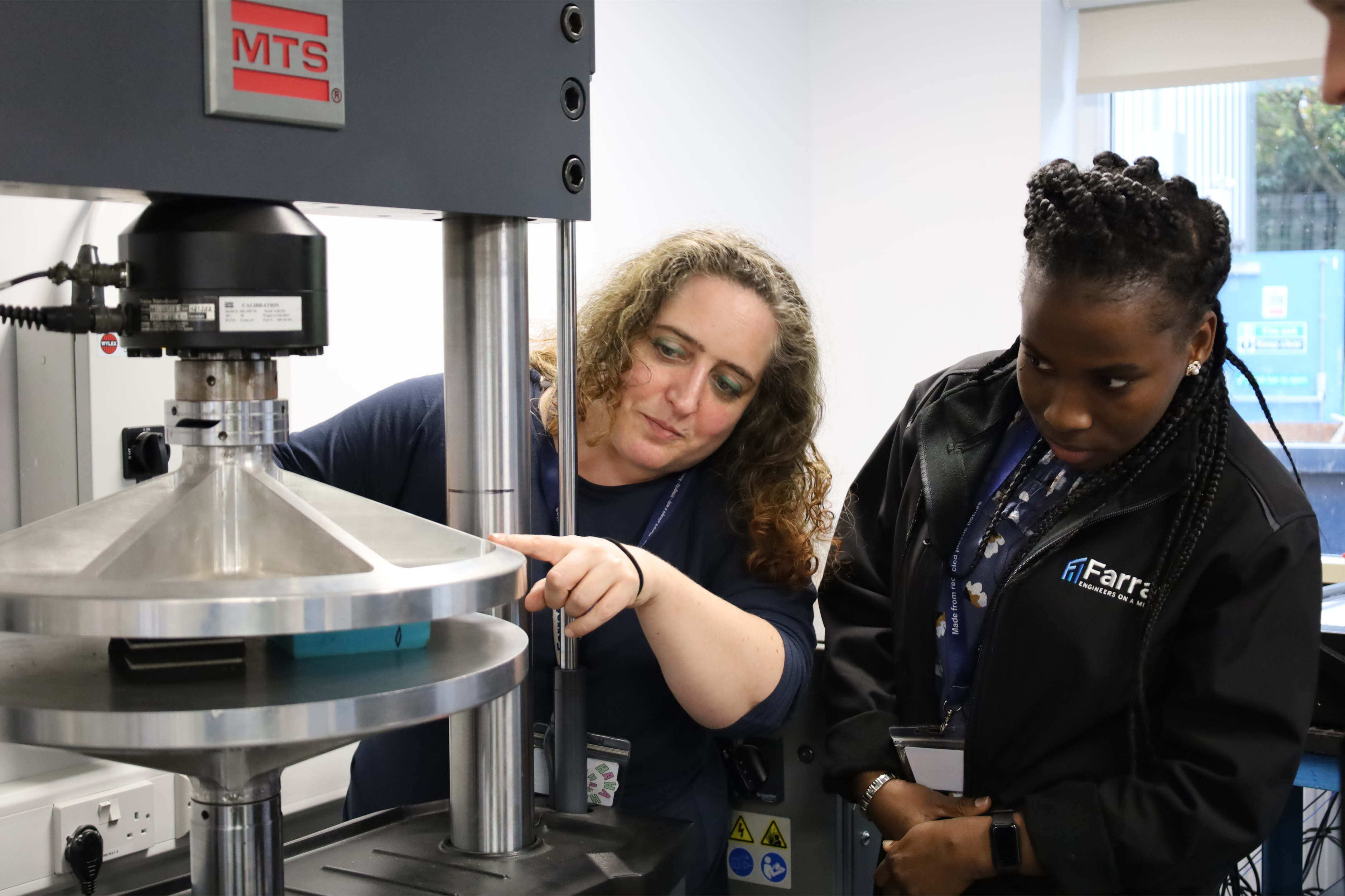 photo of two female Farrat employees examining a machine