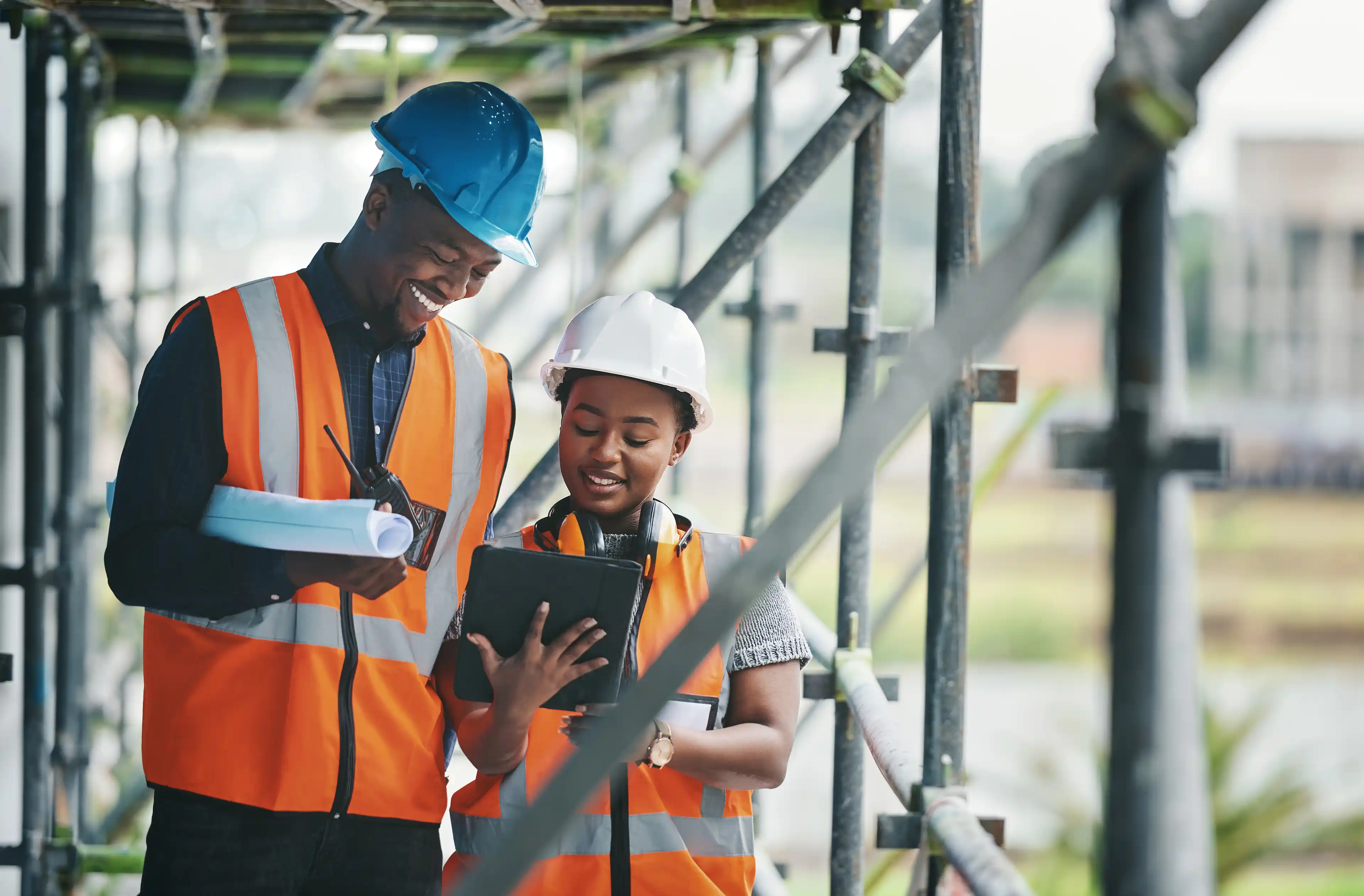 Two engineers wearing hard hats on scaffolding.