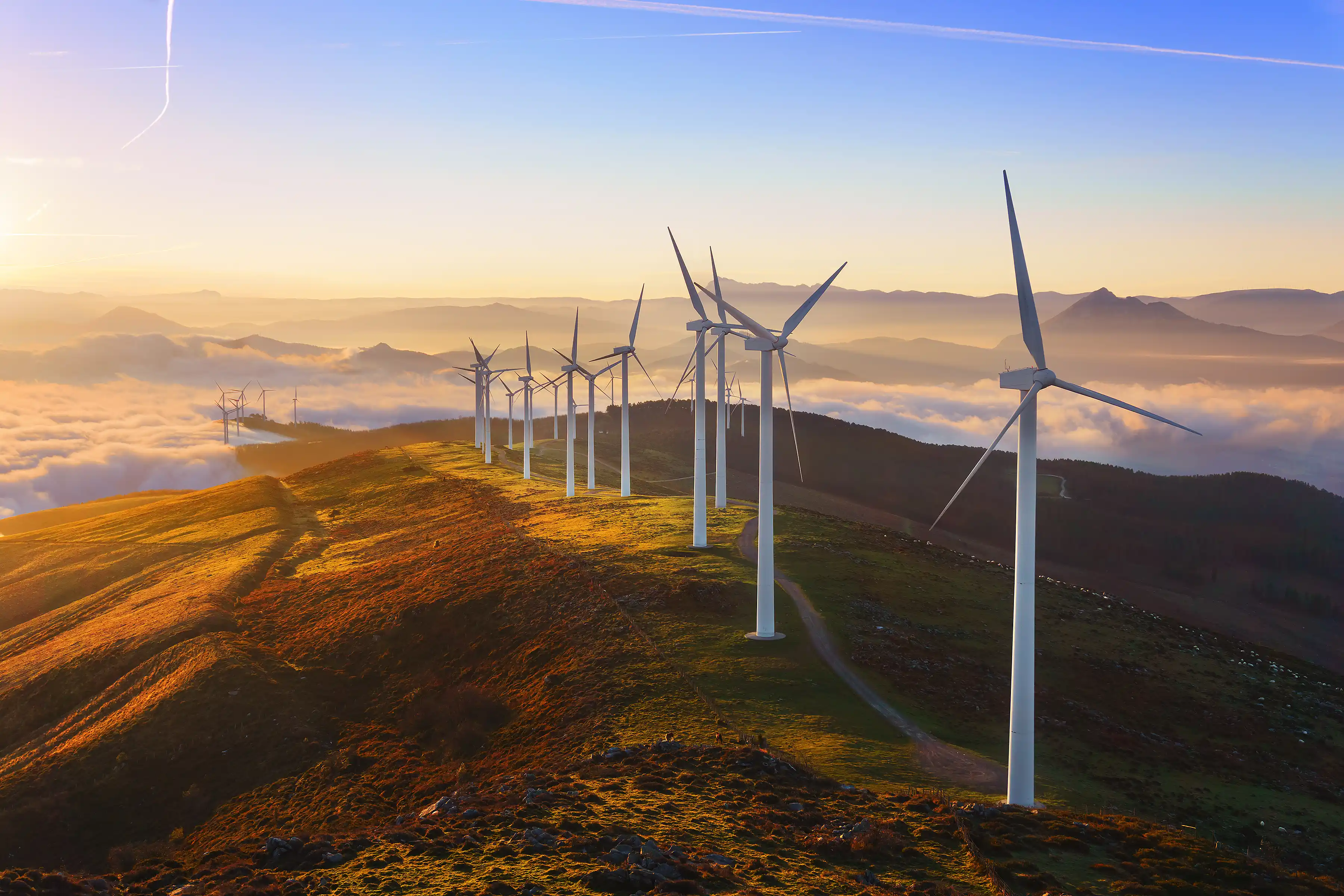 Wind turbines on a hill with the sunrise 