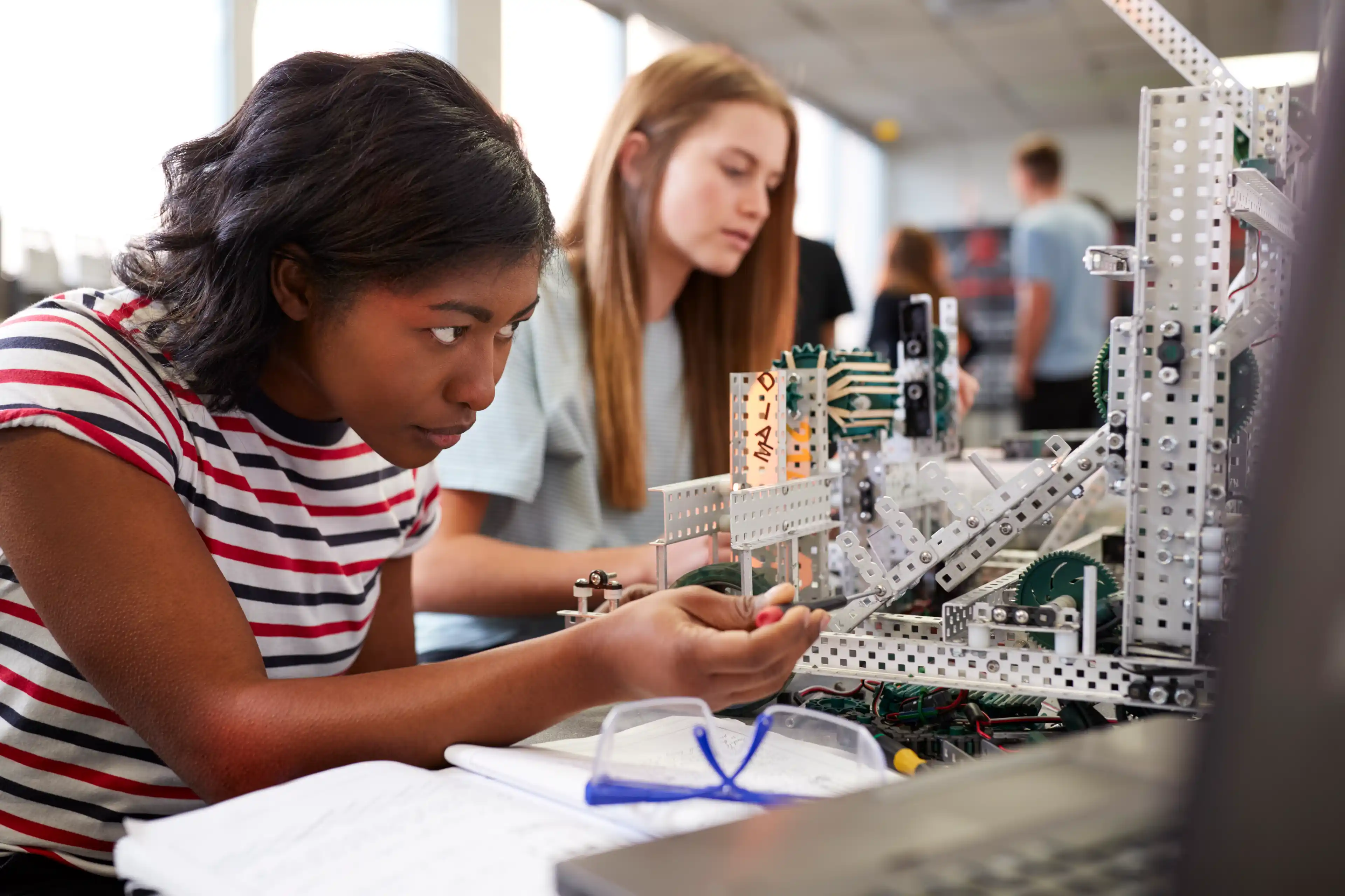 Two engineering students building a robot