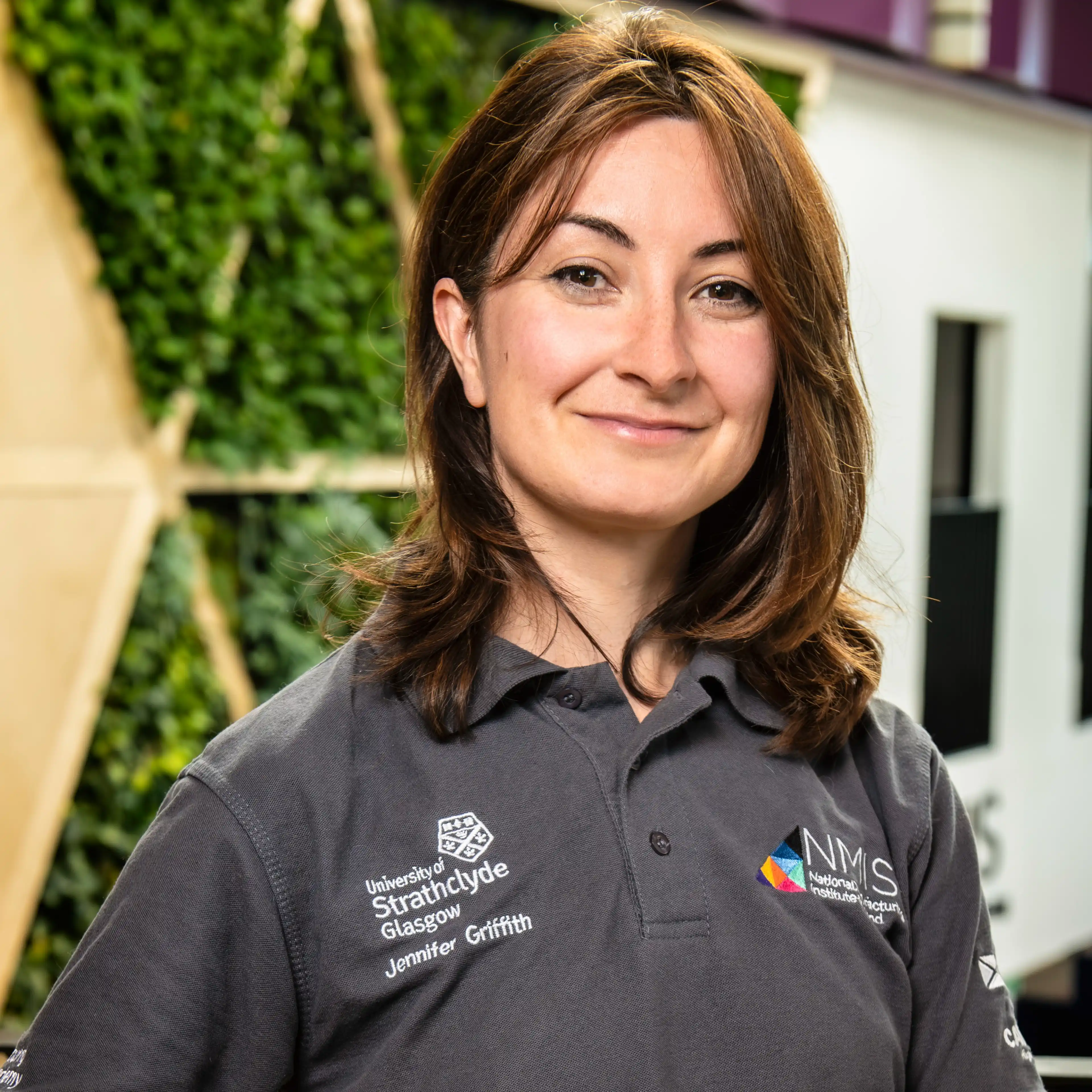 A female with long dark hair wearing a grey t-shirt