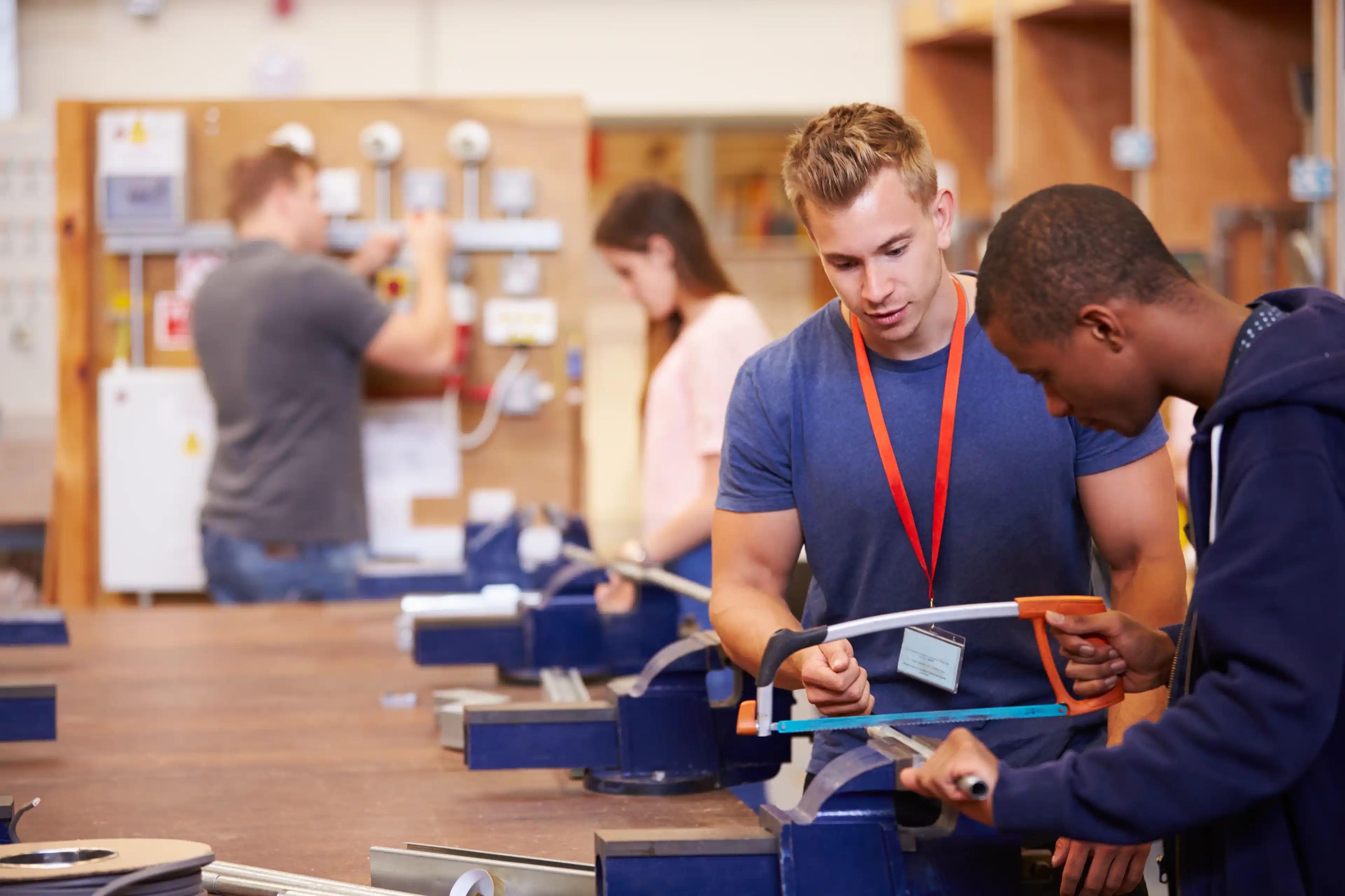 Teacher Helping Students Training To Be Electricians