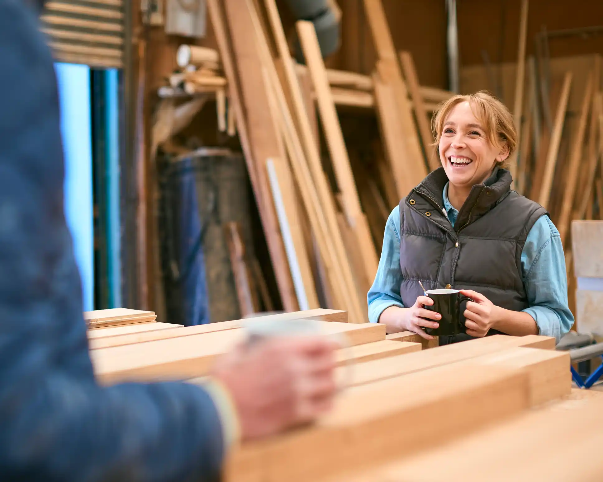 Colleagues in a woodworking shop having a coffee break