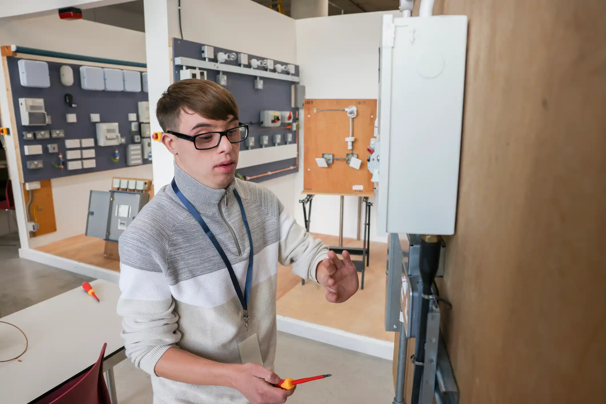 Electrical engineering apprentice working on electrical equipment in workshop