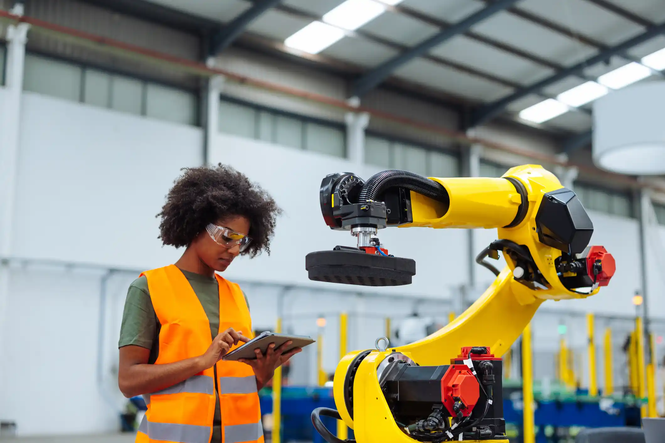 Female engineer programming a robotic arm.
