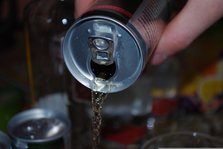 Frisdrank wordt uit blikje gegoten. 