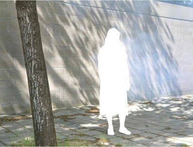 A white silhouette of a person standing in front of a wall