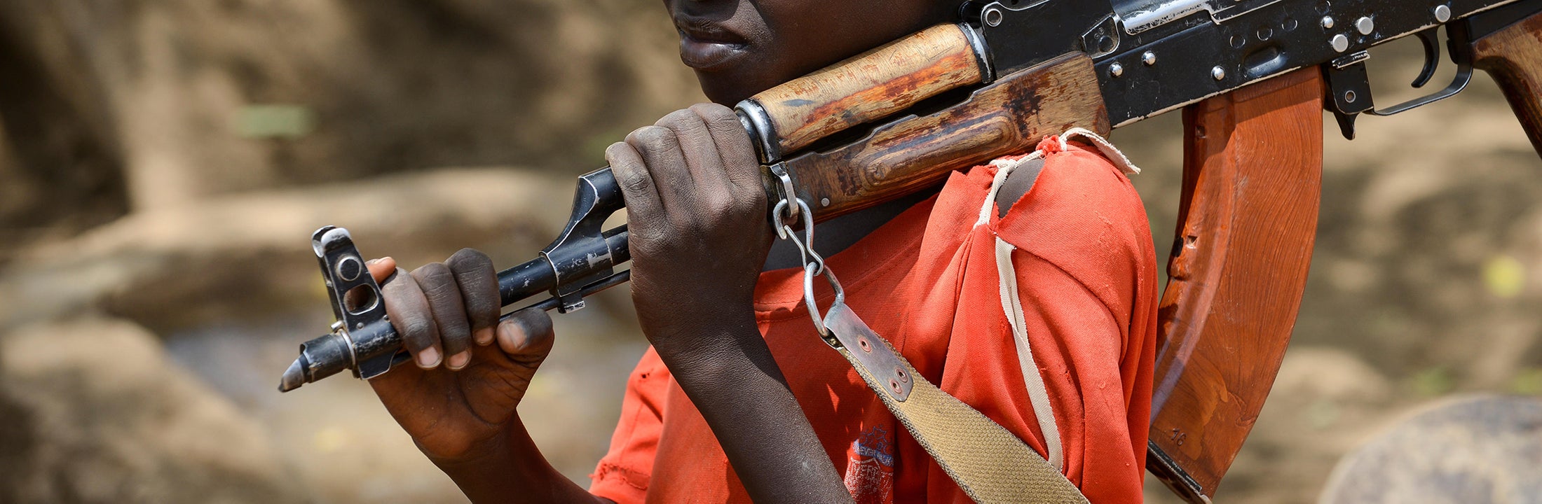 young boy walking with a gun