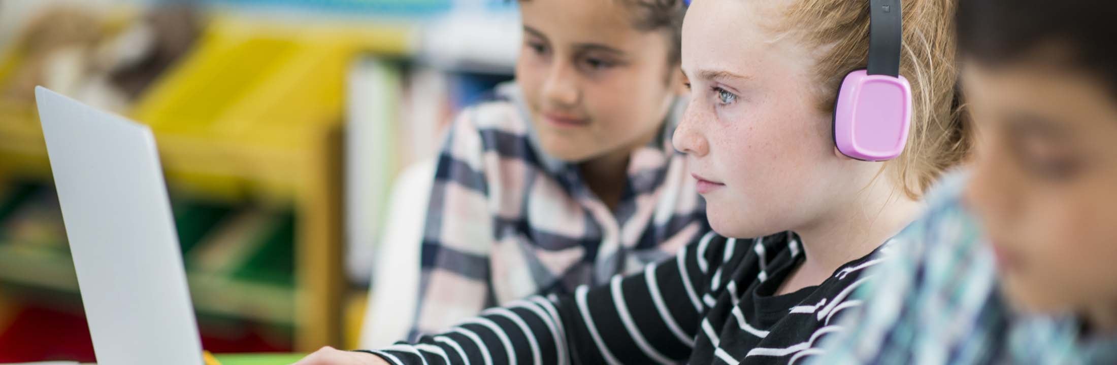 Meisje met koptelefoon en laptop