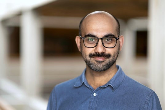A man with glasses smiling