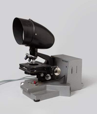 A black coloured microscope against a white background