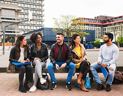 Groepje studenten op bankje op de campus