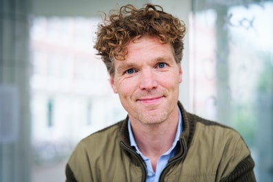 A man with curly hair smiles