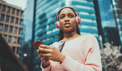 vrouw met mobiel en koptelefoon