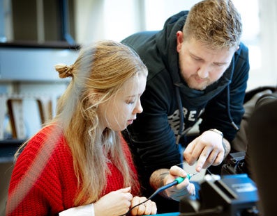 Docent geeft uitleg aan een student