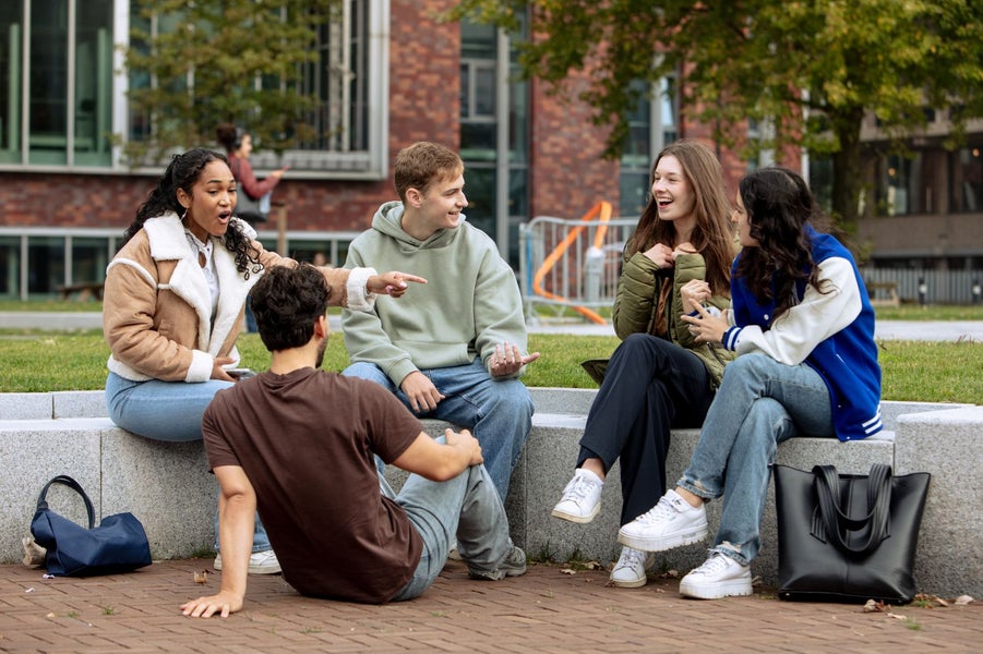 A group of people sitting on a stone bench