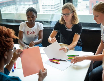 Een groep studenten rond een tafel werkend aan een opdracht