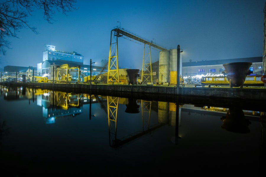 A body of water with a large metal structure and buildings in the background