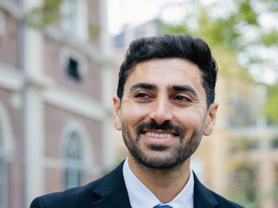 Een man in een pak glimlacht