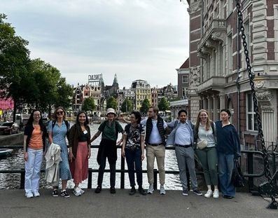 A group of people standing on on a bridge in Amsterdam